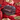 A close-up of a chocolate truffle cut in half, showing creamy caramel and white filling inside, surrounded by red and gold foil-wrapped chocolates in the background.